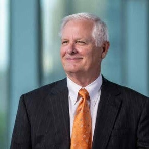 Man in black suit and orange tie.