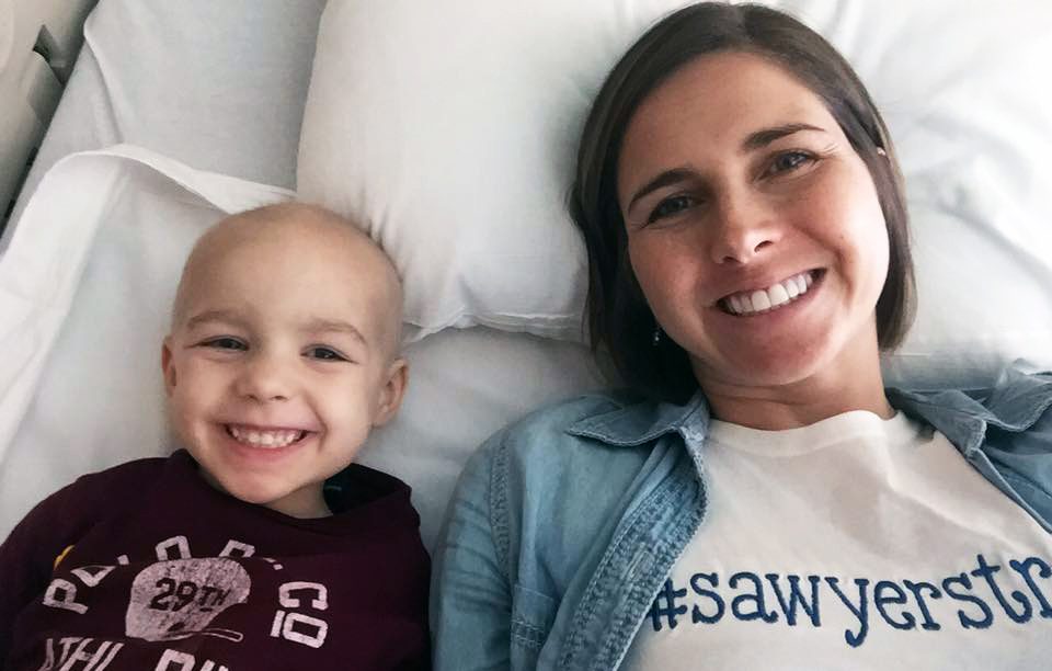 Pediatric cancer caregiver Amanda Hack next to her son, Sawyer, during his cancer treatment