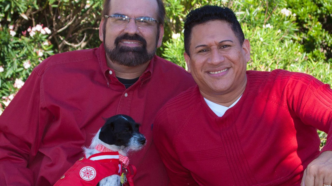 Caregiver Marlon Leiva Lopez (right) with his husband, Donald Logan, and their dog, Lola