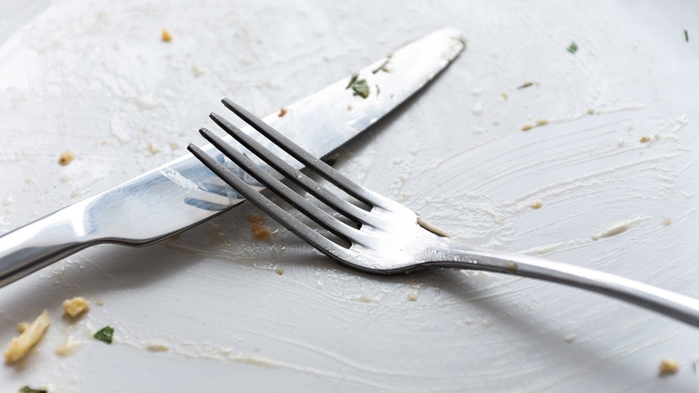 Close-up of empty, dirty plate with knife and fork