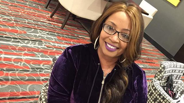 Inflammatory breast cancer survivor Dorcas Powell smiles at the camera. She is wearing glasses and has long, dark hair over one shoulder.