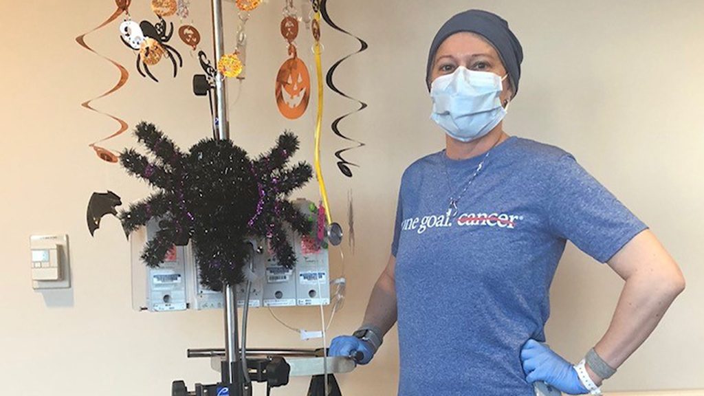 Multiple myeloma survivor Lindsay Crawford Suber, M.D., poses with her decorated chemotherapy pole in October 2018.