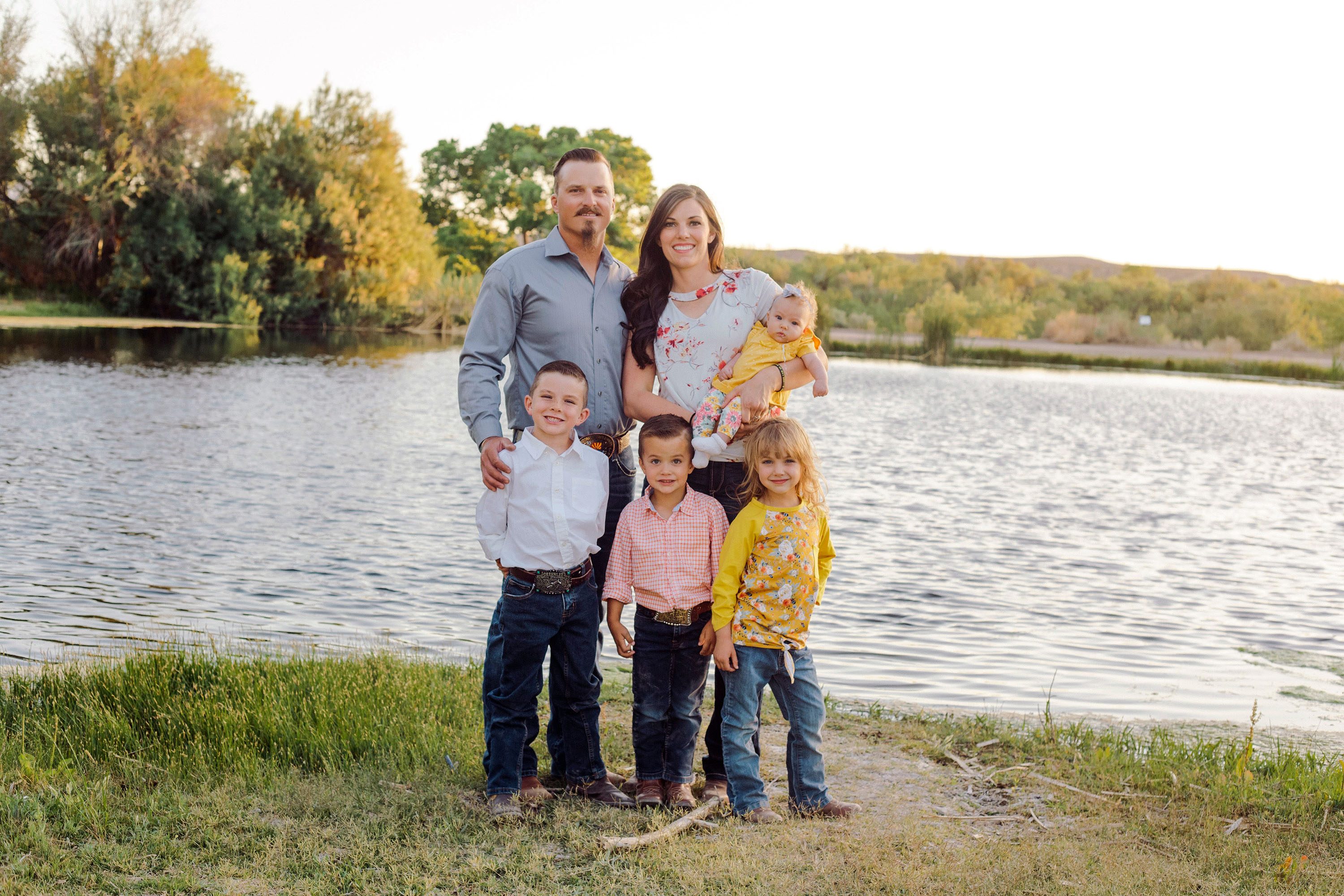 Ashton Thomas stands with his wife, Charmayne, in front of a lake with their children