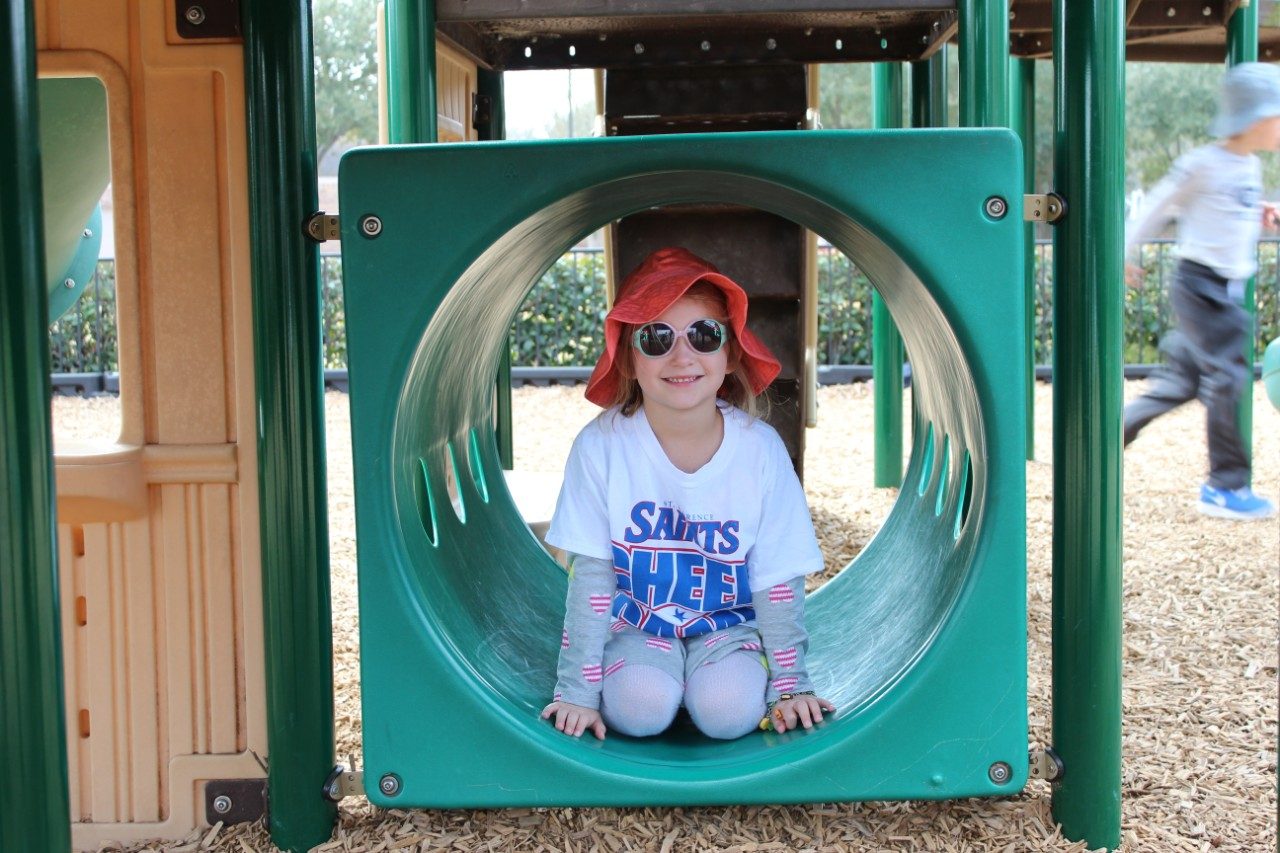 child on the playground in a hat