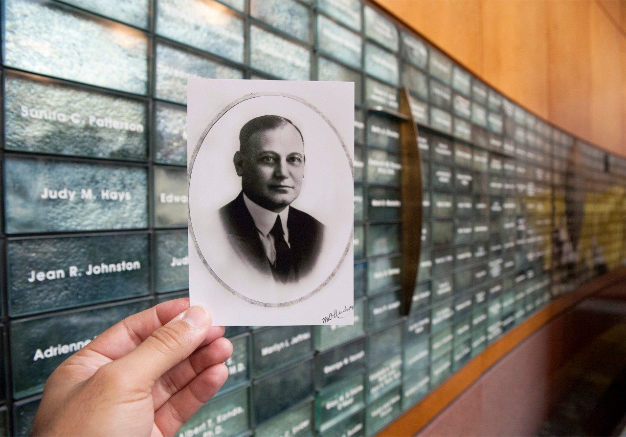 A photo of our namesake and the man whose gift made MD Anderson possible is held in front of our Donor Wall.