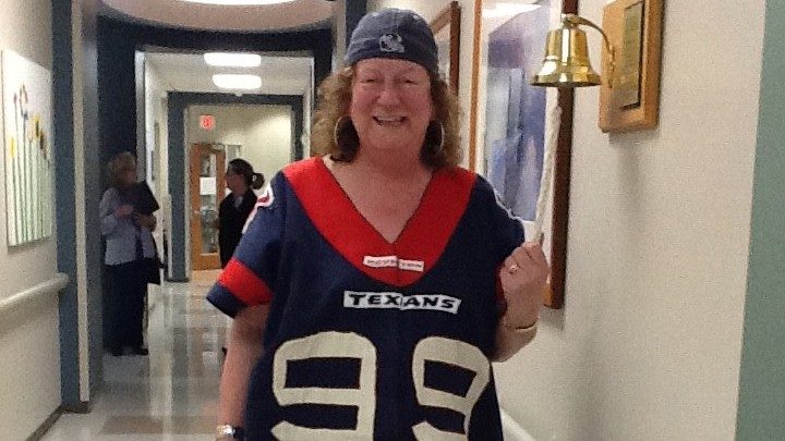 Breast cancer survivor Billa Woollam rings the bell to mark the end of treatment at MD Anderson in Katy
