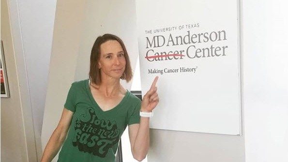 Leukemia survivor Amy Marsh poses with MD Anderson Cancer Center sign