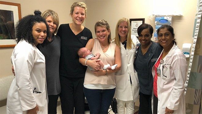 Ovarian cancer survivor Tabby Soignier with her son and her care team