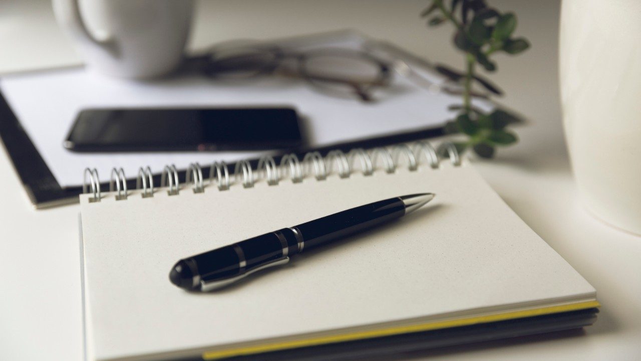 Photo of pen on top of open journal 