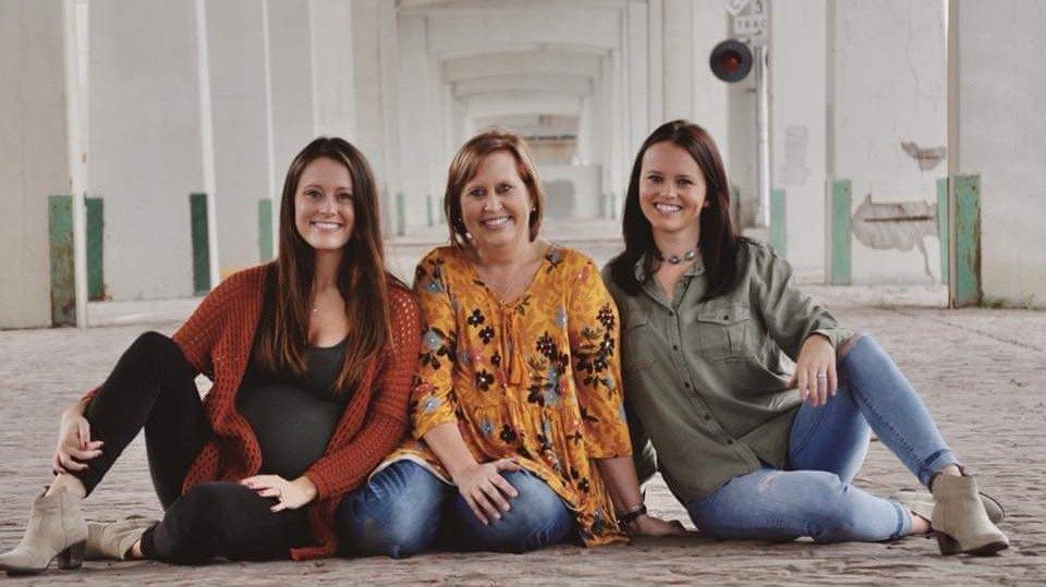 Inflammatory breast cancer survivor Tiffany Honken poses with her two daughters 