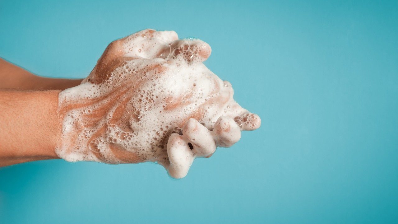 Washing hands against a blue background