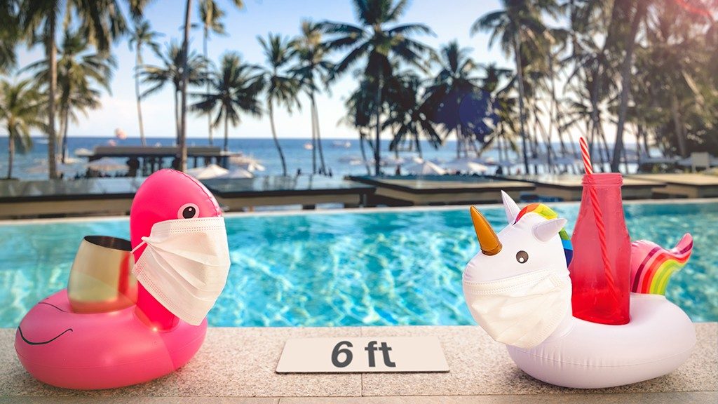 Two beverage-holder pool floats wearing face masks in tropical locale