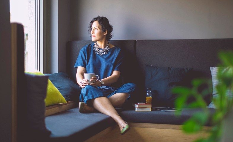woman sitting on a couch looking out the window