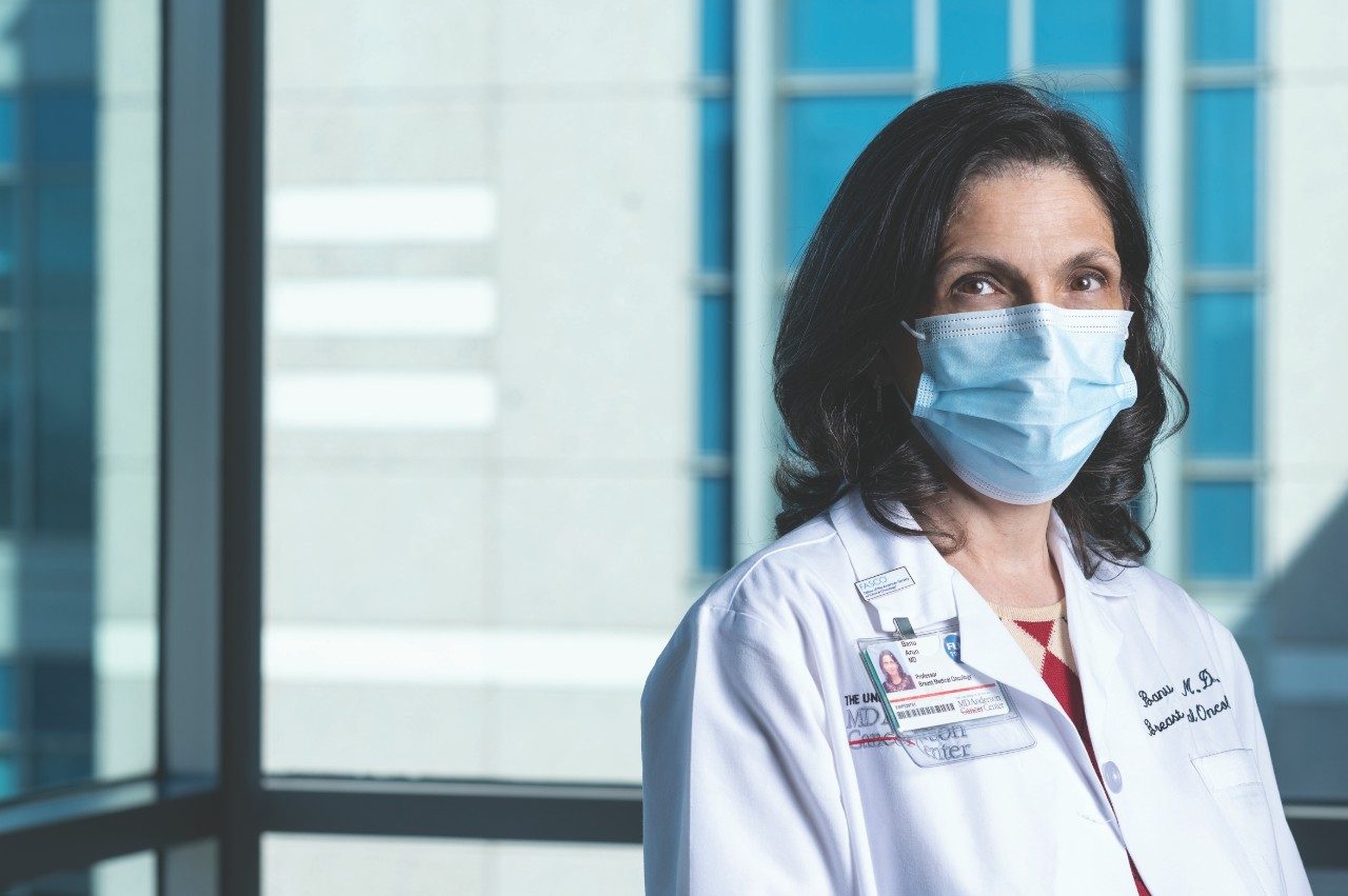 Genetic counseling and testing specialist Banu Arun, M.D., stands wearing a medical-grade face mask