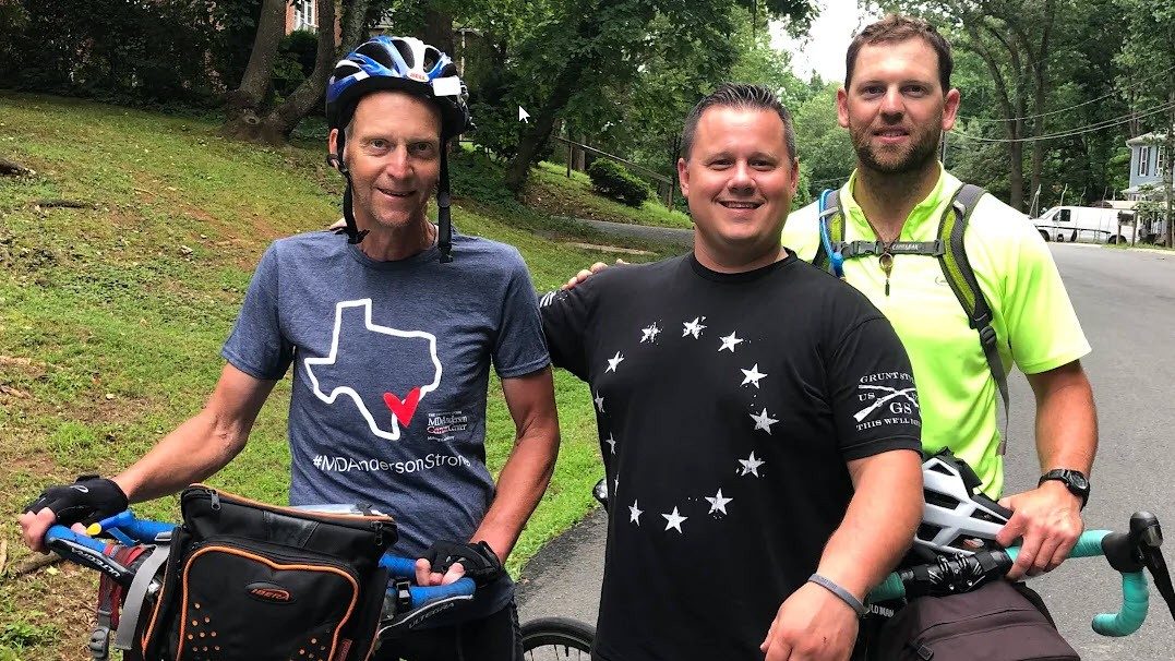 Joe Einspahr wears a helmet and holds a bike in a photo with sons Duncan (center) and Chase (right) 