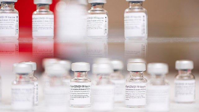 Close-up of vials of COVID-19 vaccine on glass shelves