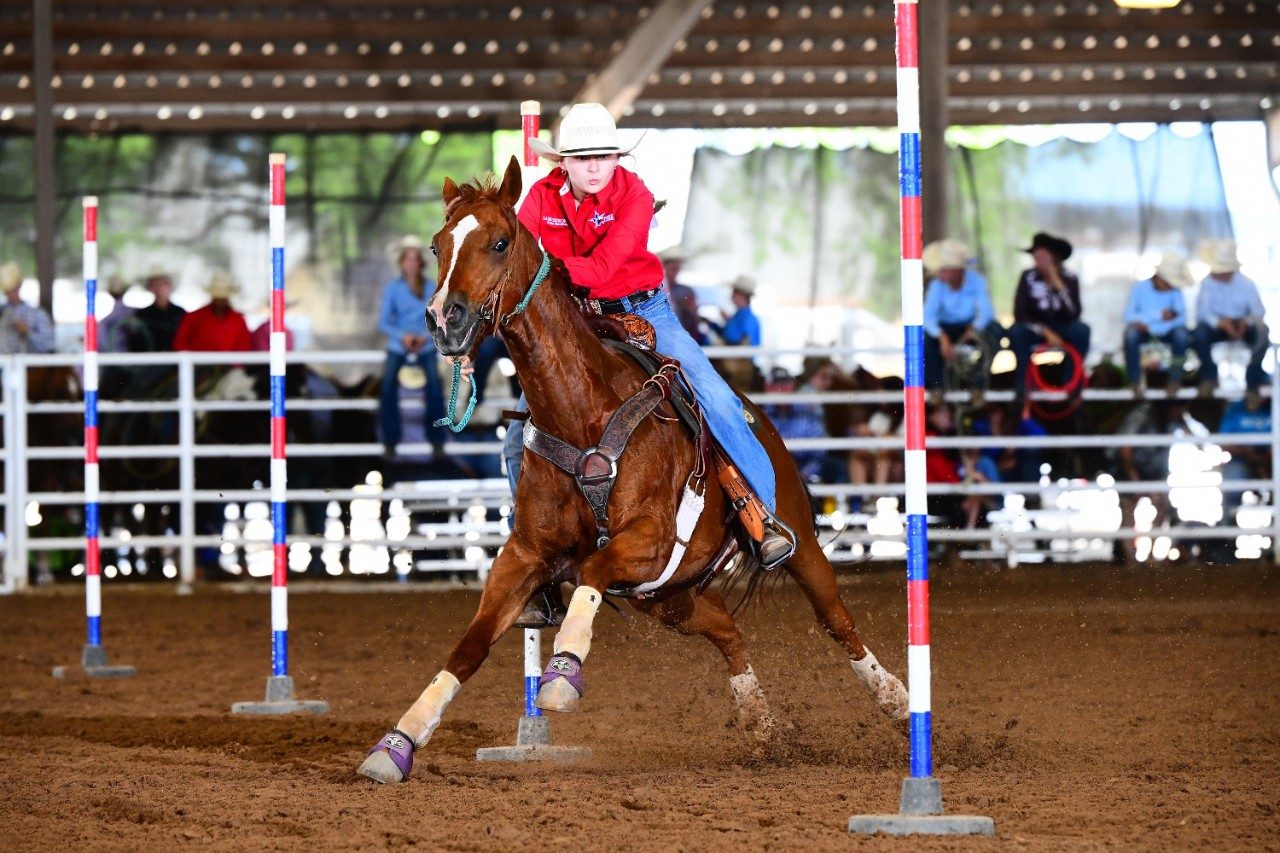 Lane Thibodeaux riding a horse during a rodeo in an arena.