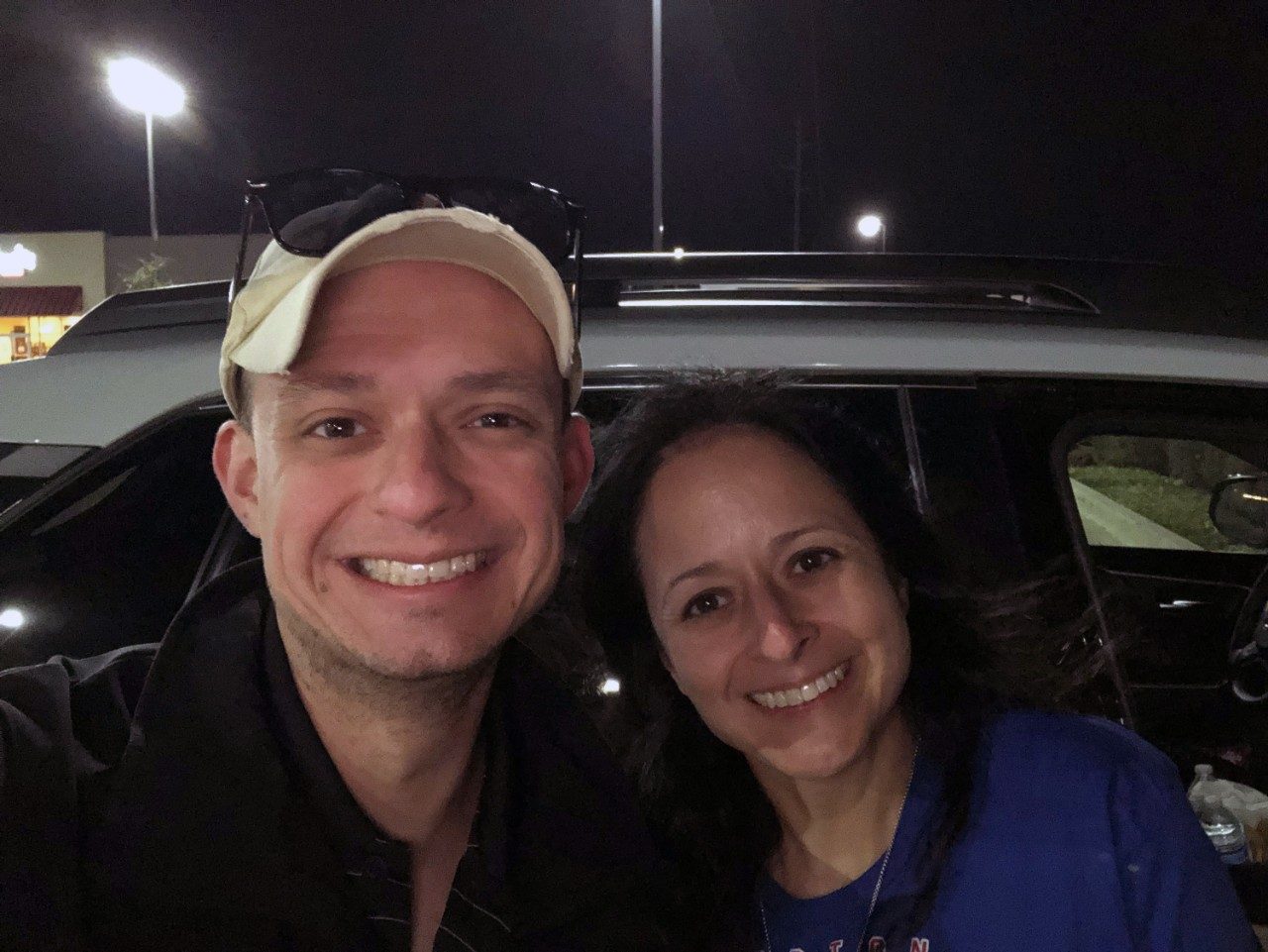 Michael Scott  smiles with his arm around his mom outside at night.