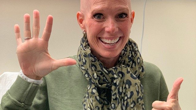 Cervical cancer survivor Linda Ryan, holding up six fingers to show how many relapses she's had