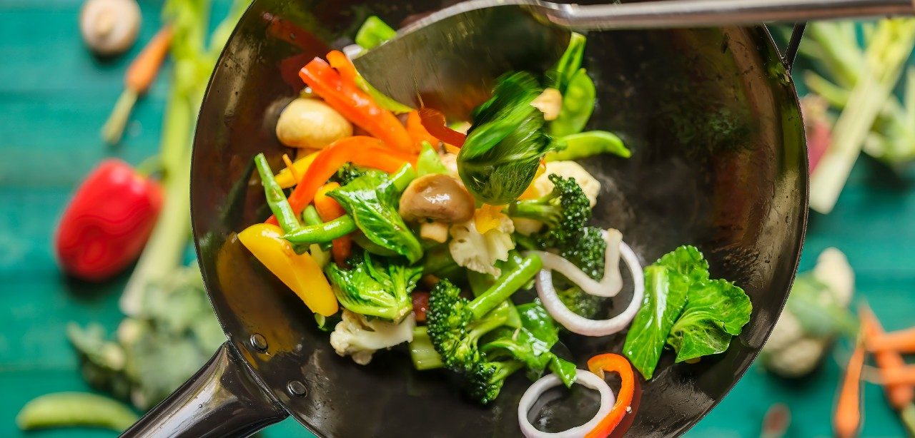 Stir fry vegetables in a skillet.