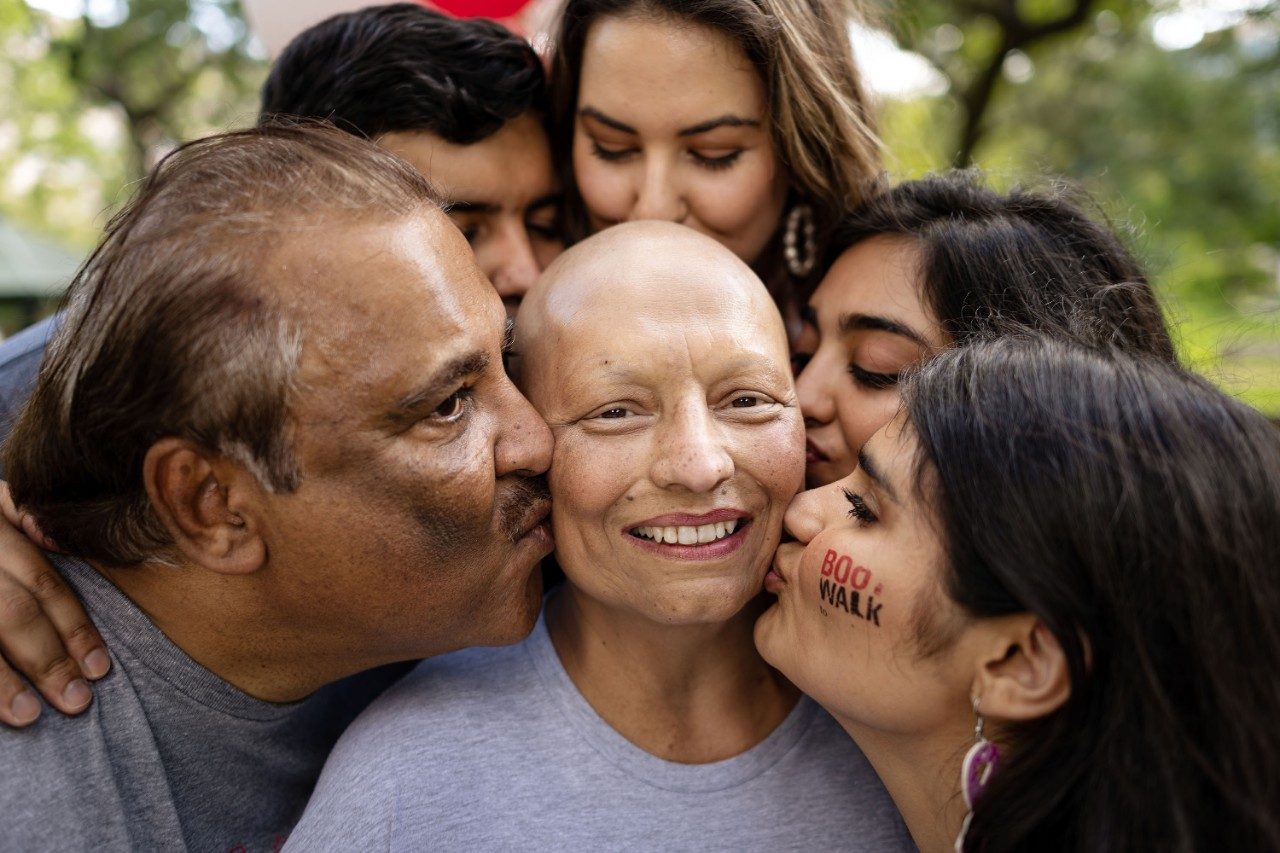 Archna Chainani is surrounding by her family as they lean in to kiss her