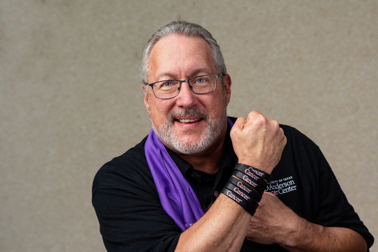 Doyle Bosque shows off cancer strikethrough wristbands stacked up on his wrist.