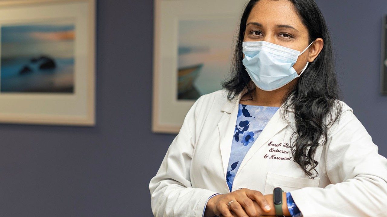Sonali Thosani, M.D., poses in a white lab coat at her clinic