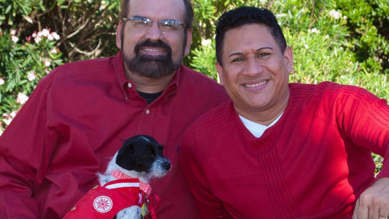 Caregiver Marlon Leiva Lopez (right) with his husband, Donald Logan, and their dog, Lola