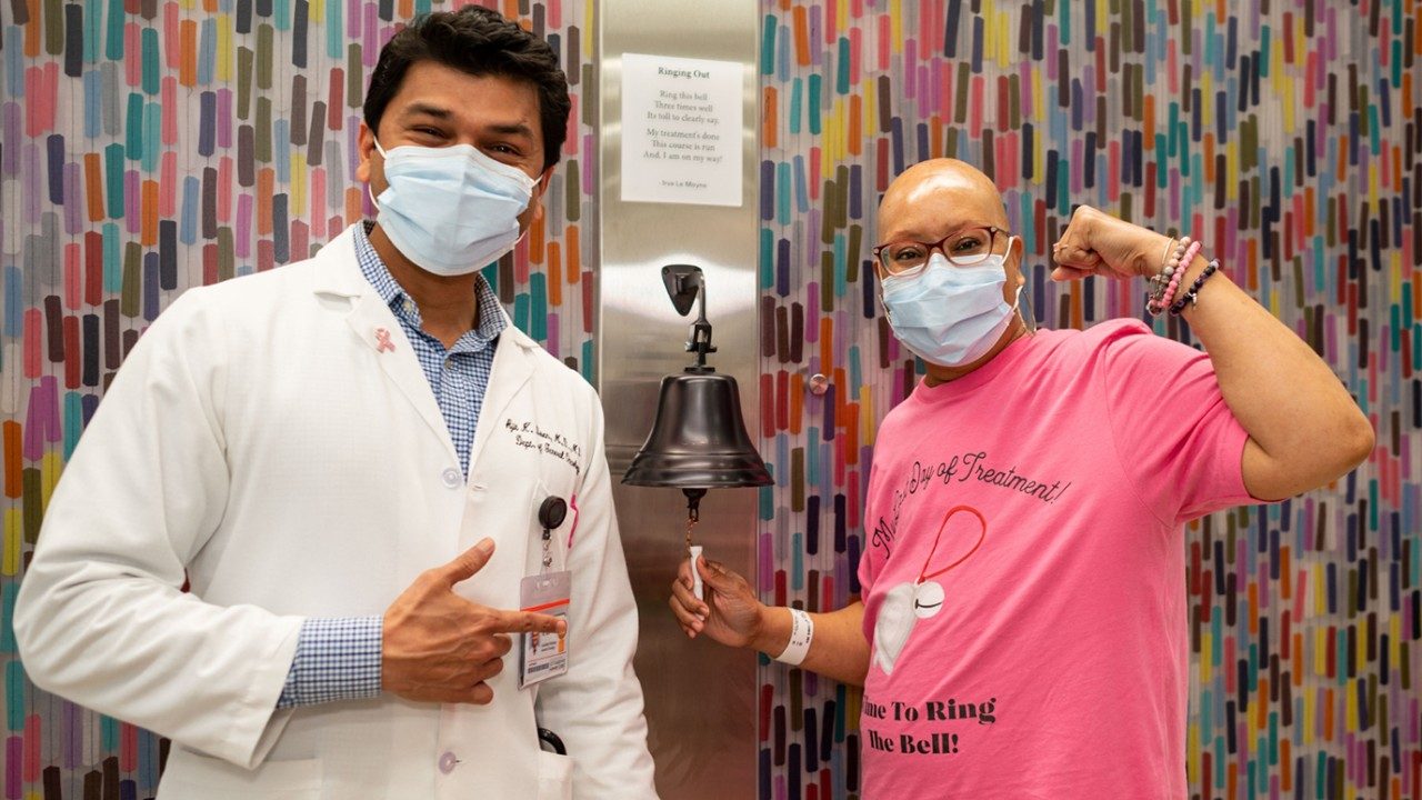 Breast cancer survivor and MD Anderson employee Scottie Chatman rings the bell next to Ajit Bisen, M.D., at MD Anderson West Houston