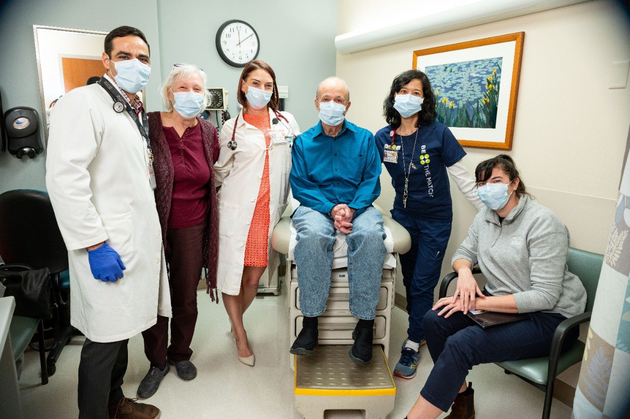 Curt Bogard visits his care team in clinic with his bone marrow donor Thea Champlin.
