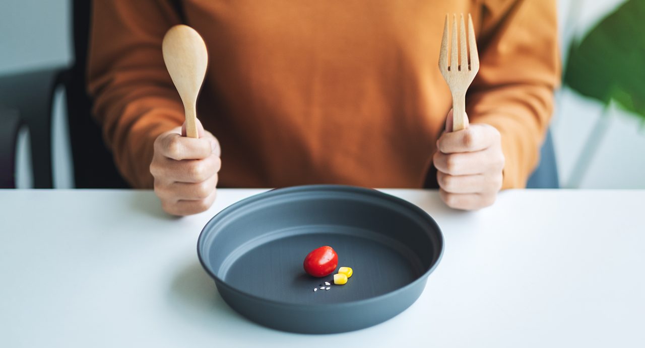 Close-up of dieter's plate with only a few vew small food items on it