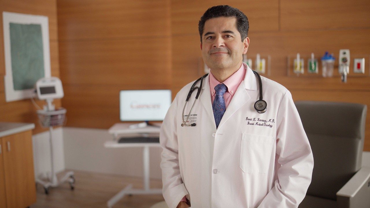 Dr. Ramirez standing in patient room wearing a white lab coat