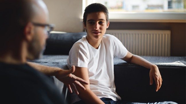 Teen is seen talking with older adult