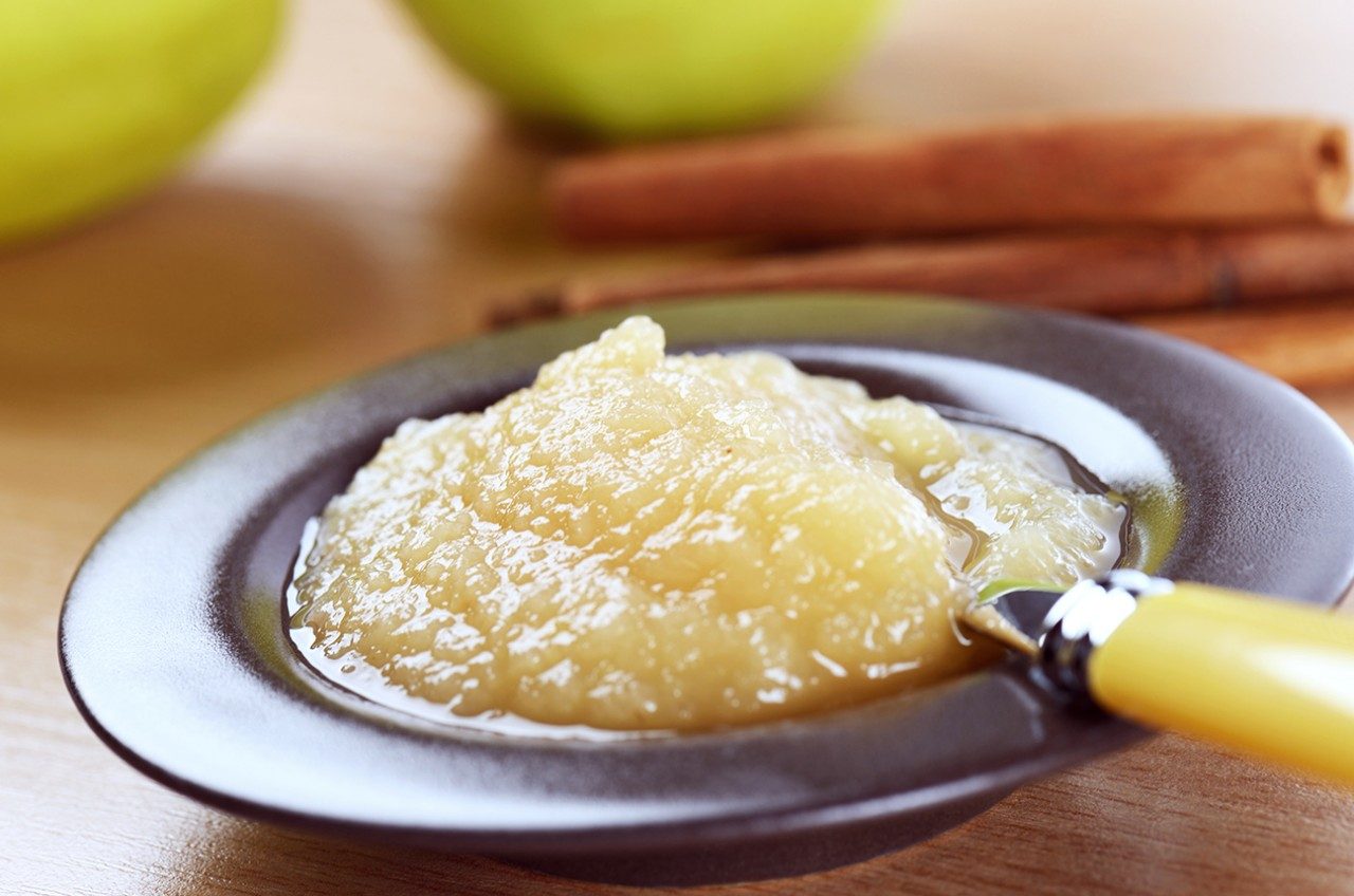 A bowl of applesauce with a spoon in it