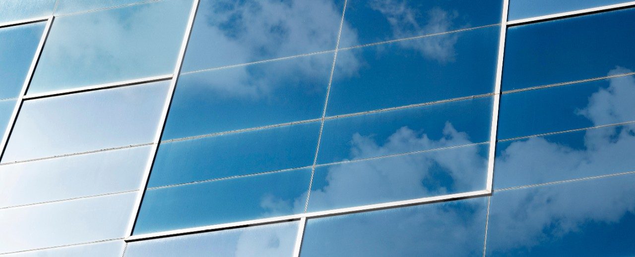 Clouds and sky reflected in blue glass windows