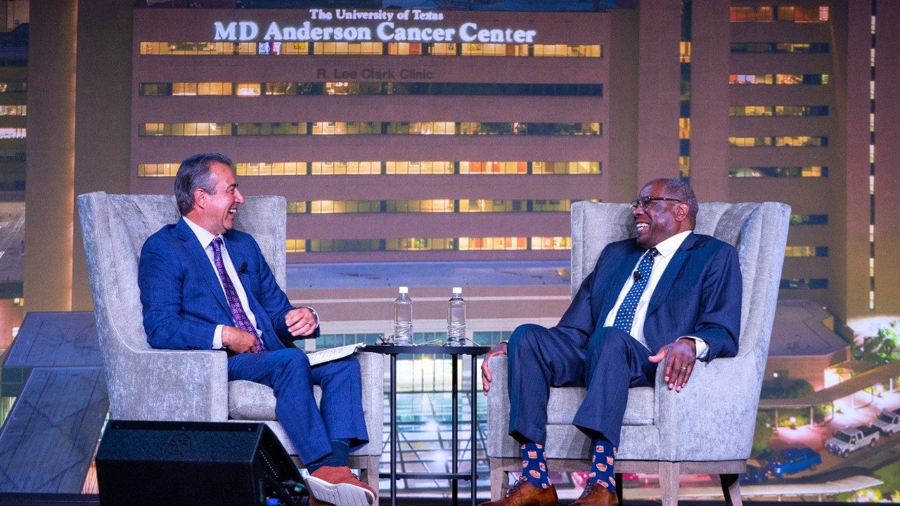 Todd Kalas interviews Dusty Baker on stage, both sit in high-back chairs and are smiling.
