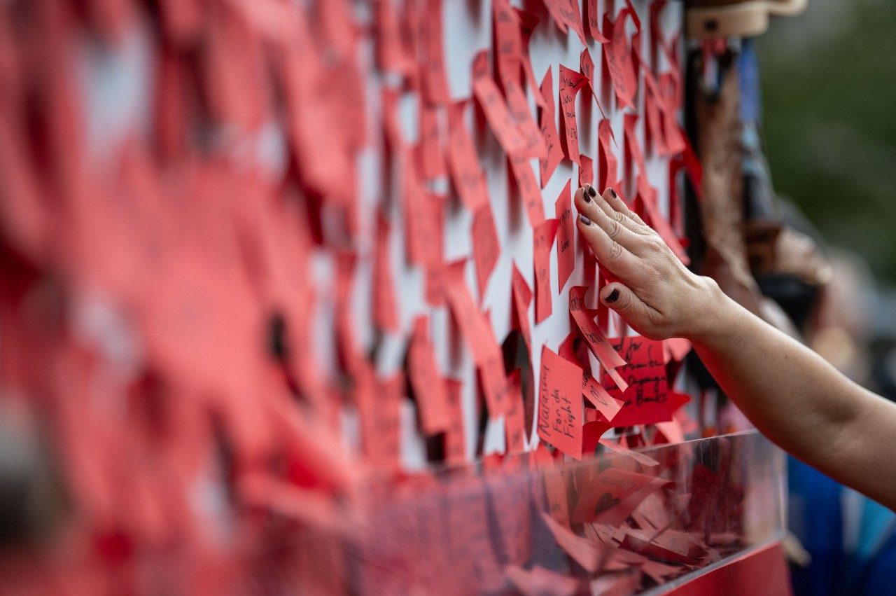 Participant adds a name to the cancer strikethrough wall.