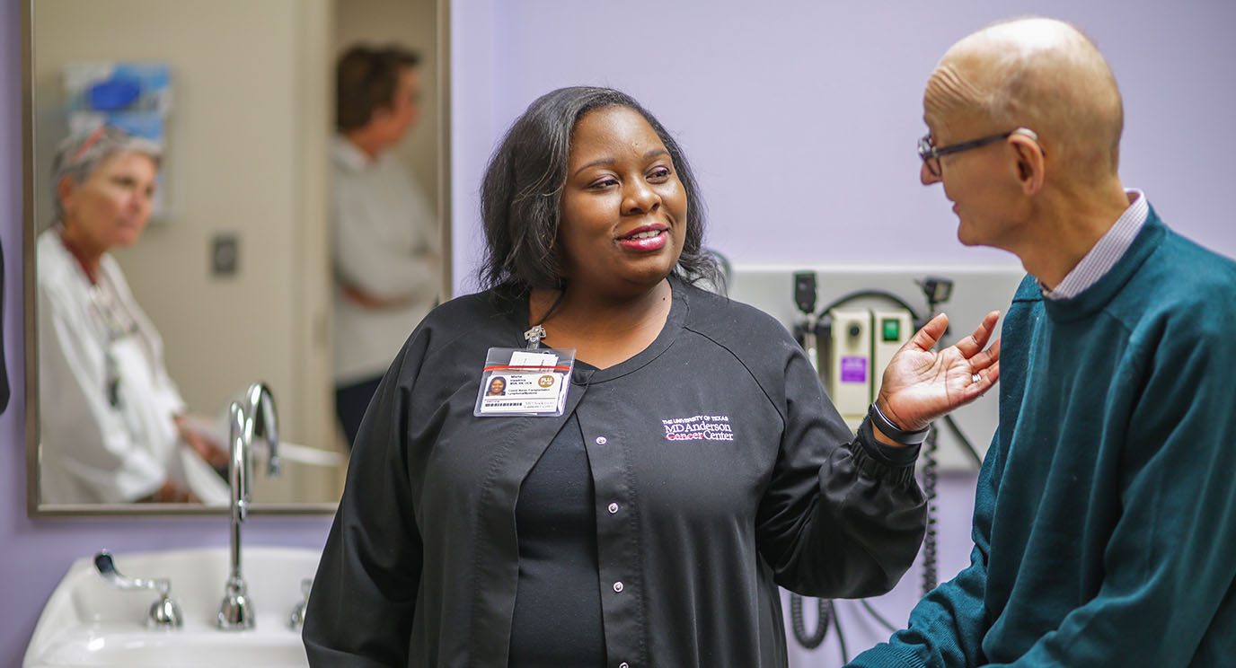 Cell therapy coordinator Misha Hawkins consults with patient Robin Bartels
