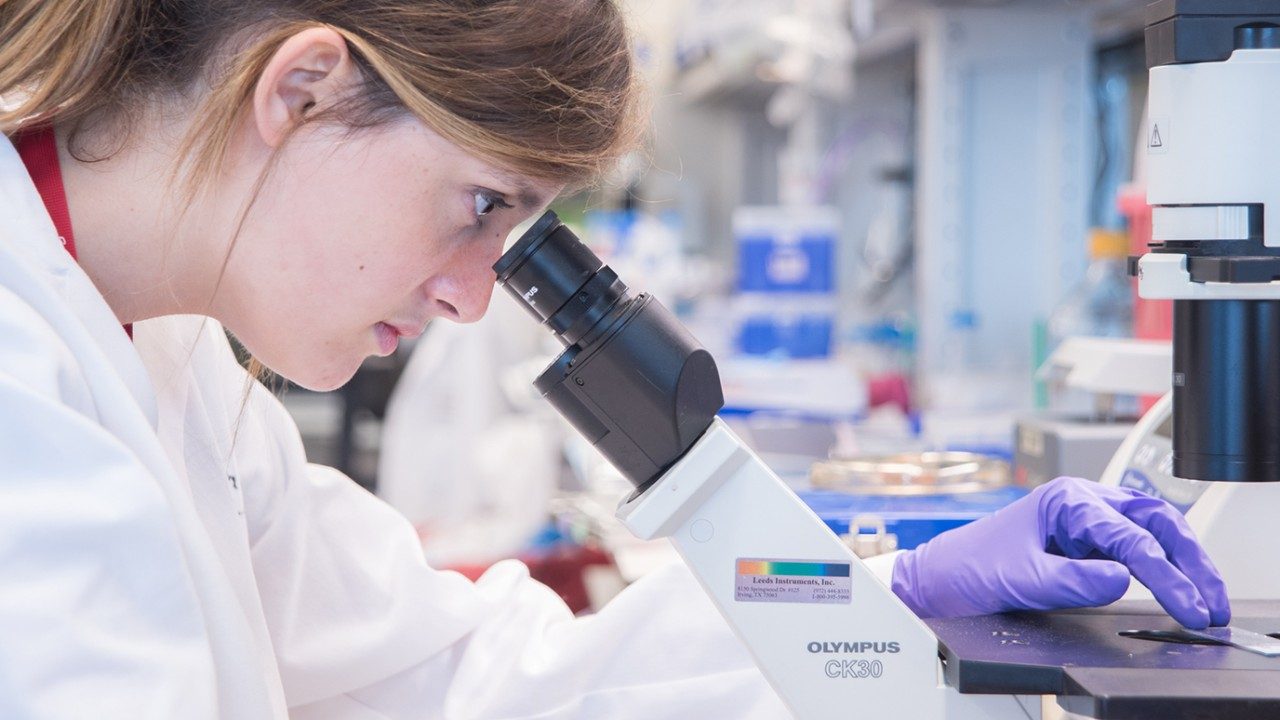researcher in lab with microscope