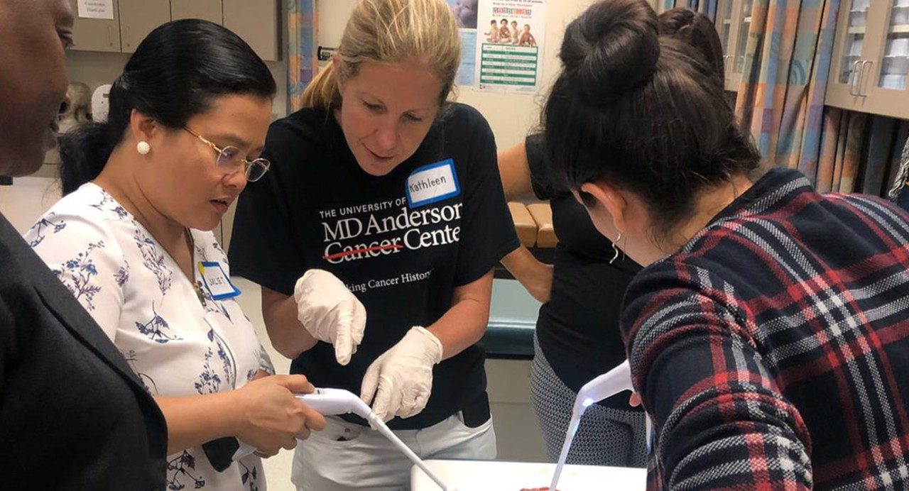 Kathleen Schmeler, M.D., teaching thermoablation to medical providers at a cervical cancer prevention training course in Tyler, Texas. Thermoablation applies heat to remove precancerous growths detected during cervical cancer screening. 