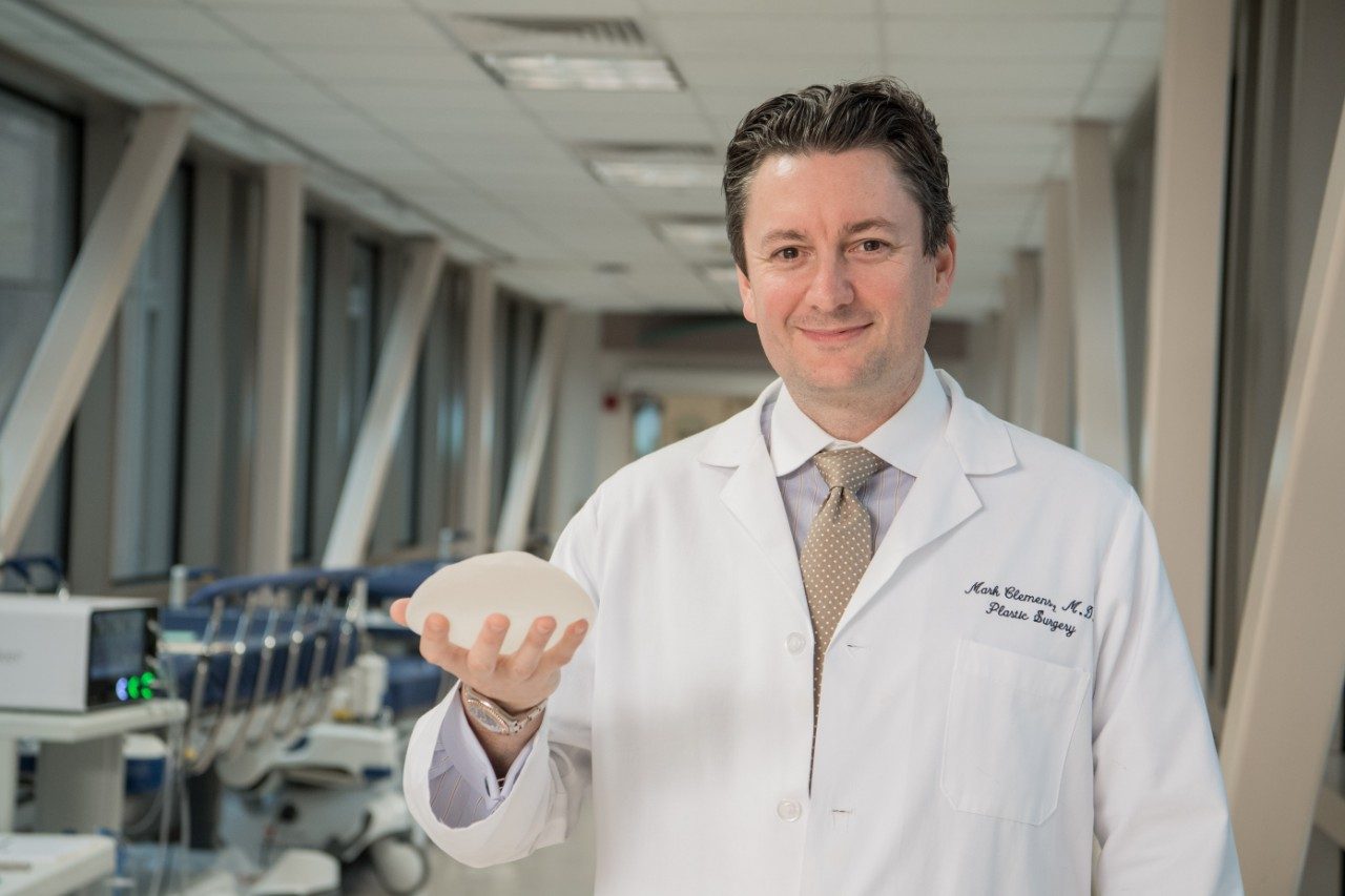 Breast implant-associated anaplastic large cell lymphoma expert Mark Clemens, M.D., holds a textured breast implant. 