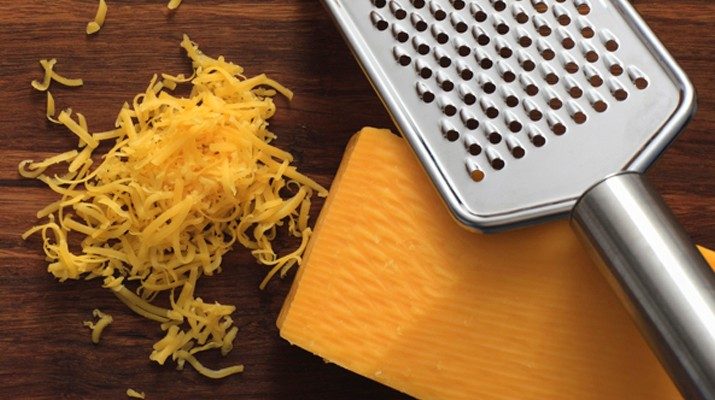 Block of cheddar cheese with grater