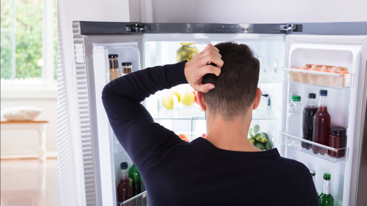 Man looks in fridge and scratches head
