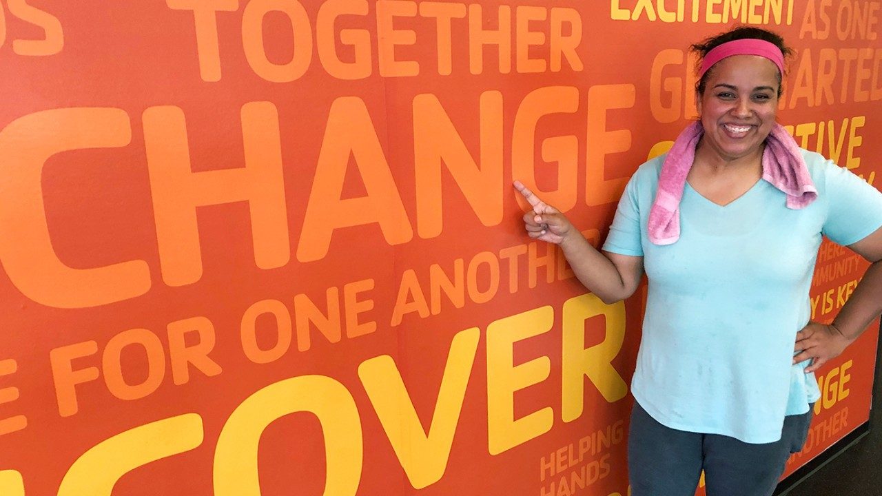 Adriana Mercado with mural that reads: change