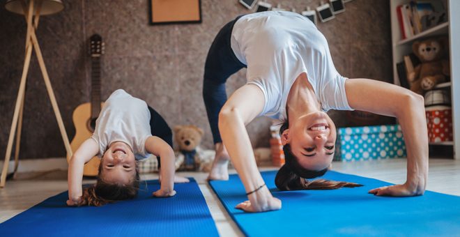 Mom and daughter exercise in their living room