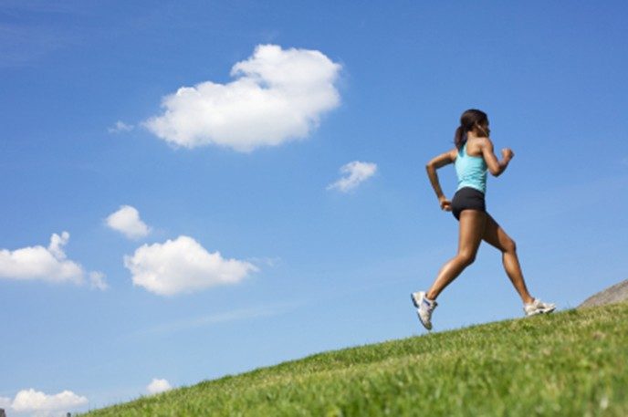 woman running up a hill to exercise for cancer risk reduction