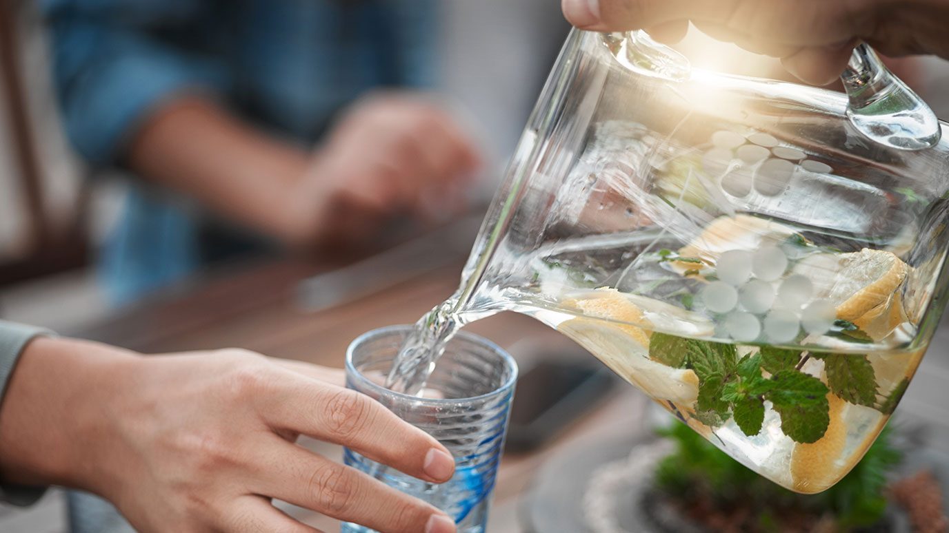 someone pouring water from a pitcher