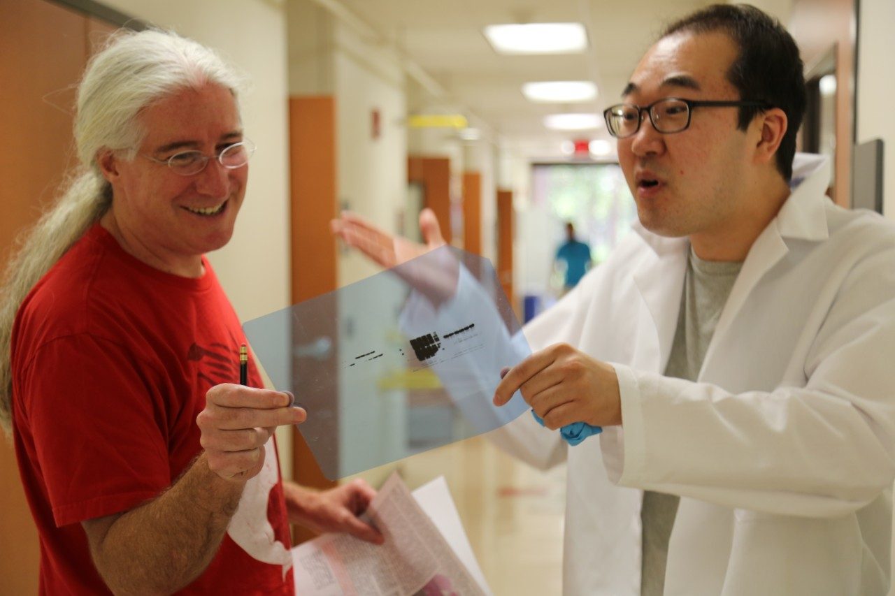 Mark Bedford and Dr. Narkhyun Bae discussing experimental results.