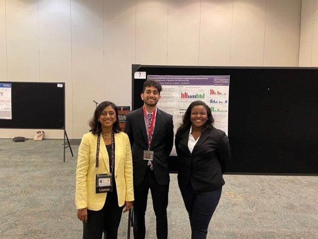 two summer student interns posing with Personal Investigator, Joya Chandra, at poster presentation.