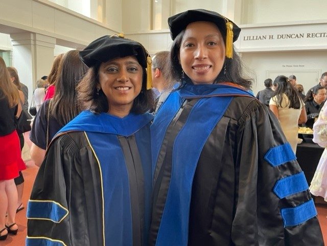 Mary, student, and Dr. Chandra pose together for a picture in graduation attire at commencement.